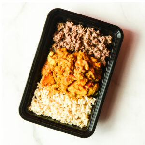 Cluck The Bean: Black meal container with ground meat, orange-sauced chicken, and brown rice arranged in three sections on a white surface.