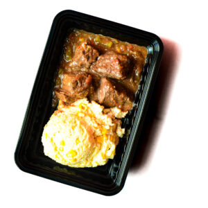Operation Cajun Fit features beef stew in gravy with mashed potatoes and corn, all served in a black plastic container.