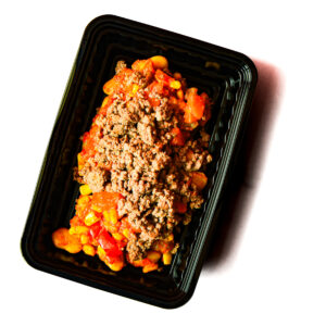 Operation Cajun Fit features ground beef, corn, beans, and diced tomatoes in a black plastic meal tray on a white background.