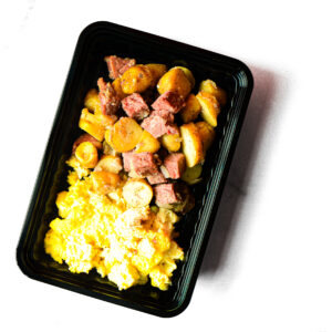 A black meal tray with Chickpeas & Beef? Savvy! on a white background.