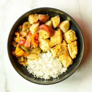 Chicken & Rice 9000: a bowl with white rice, cooked chicken, roasted red potatoes, and sautéed bell peppers and onions.