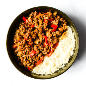 Alfredo del Bombero: a bowl of cooked ground beef with red bell peppers and onions, served with white rice.