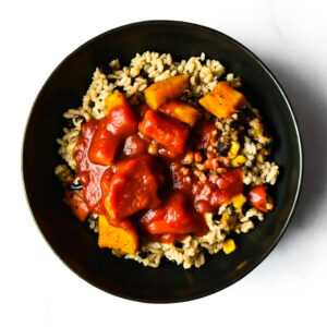 The F*d Up Fajita: a black bowl with rice, corn, black beans, veggies, and a red tomato-based sauce.