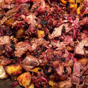 Close-up of Stop Looking At My Hash!—chopped, cooked beef mixed with roasted potatoes and veggies, featuring browned and charred textures.