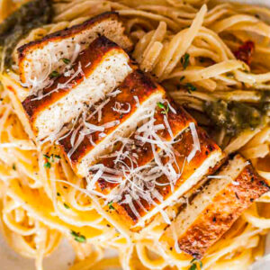 Tof*cked Up Vodka pairs perfectly with grilled chicken breast over fettuccine, topped with cheese and a green sauce garnish.