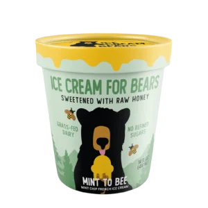 A pint of Queen & Bean mint chip French ice cream, sweetened with raw honey, features a bear illustration and is labeled grass-fed dairy with no refined sugars.