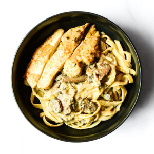 A bowl of pasta with meat and sauce.