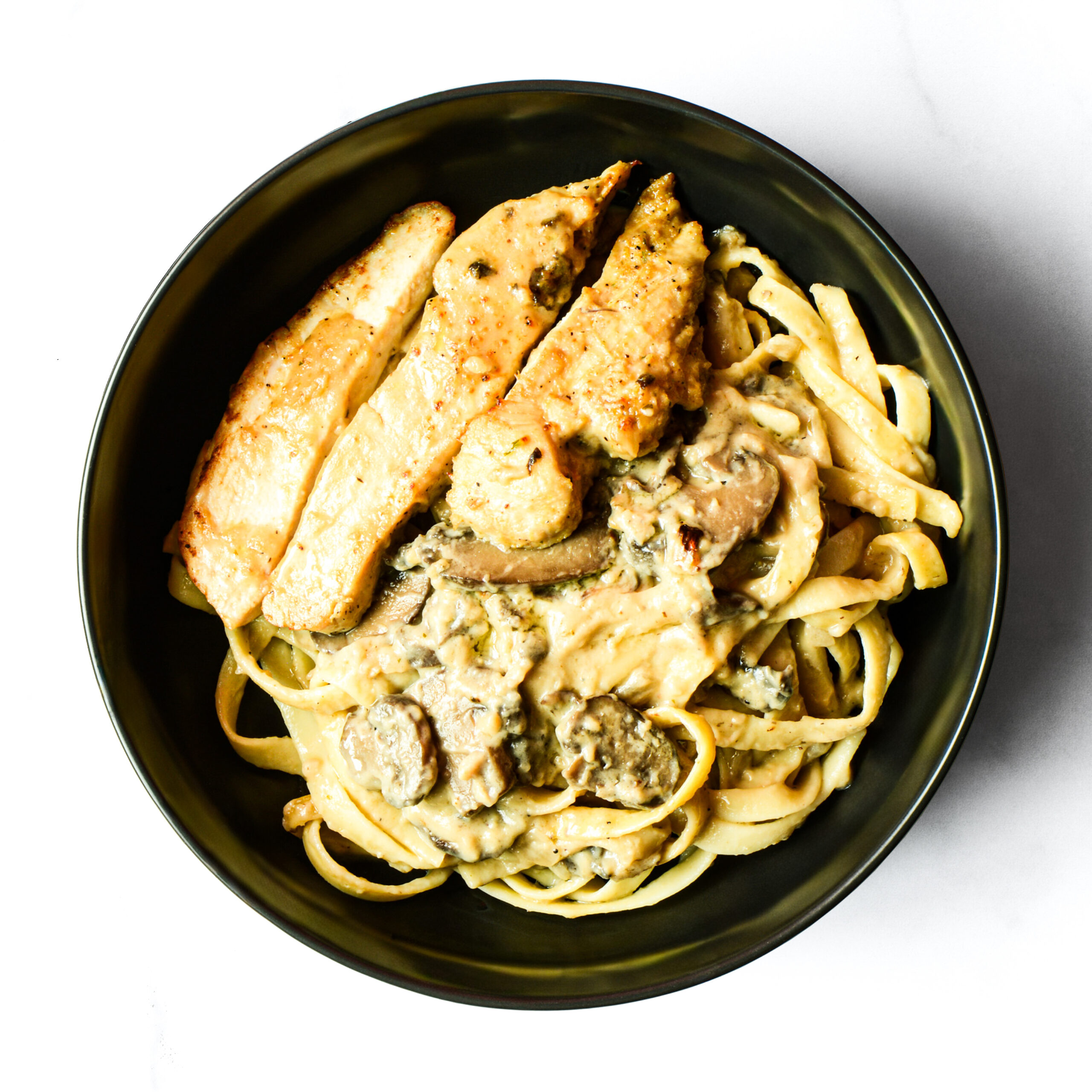 A bowl of pasta with meat and sauce.