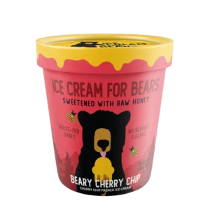 A pink and yellow Beary Cherry Chip ice cream container, with a bear illustration, highlights grass-fed dairy and no refined sugars. Coming soon!.